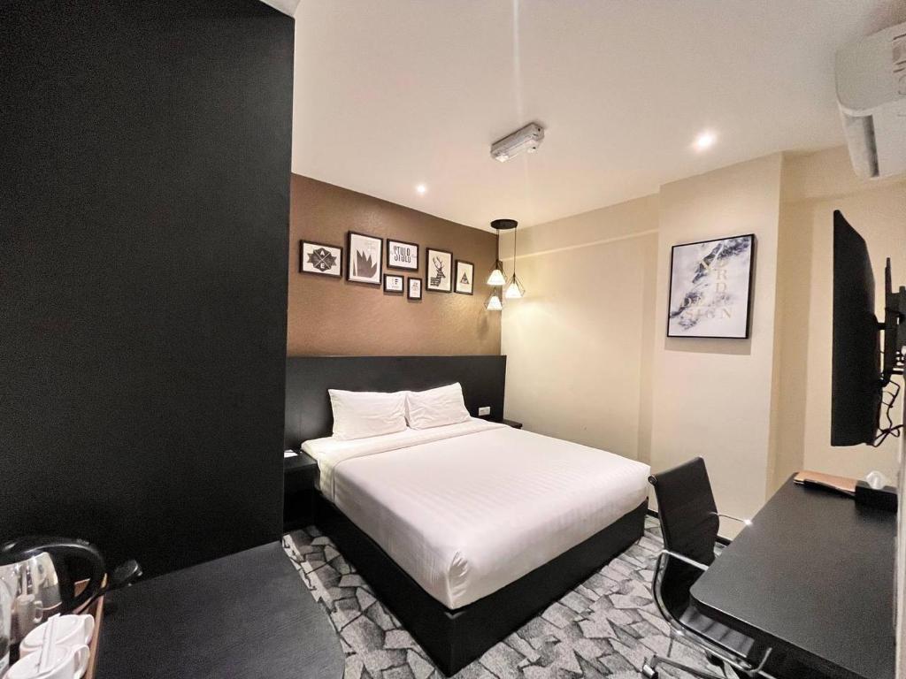 吉隆坡和平酒店的卧室配有白色的床和书桌