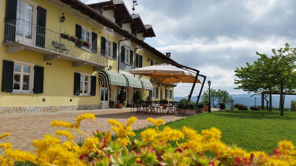 迪亚诺达尔巴卡希纳拉巴罗特农庄酒店的黄色的建筑,设有庭院和雨伞