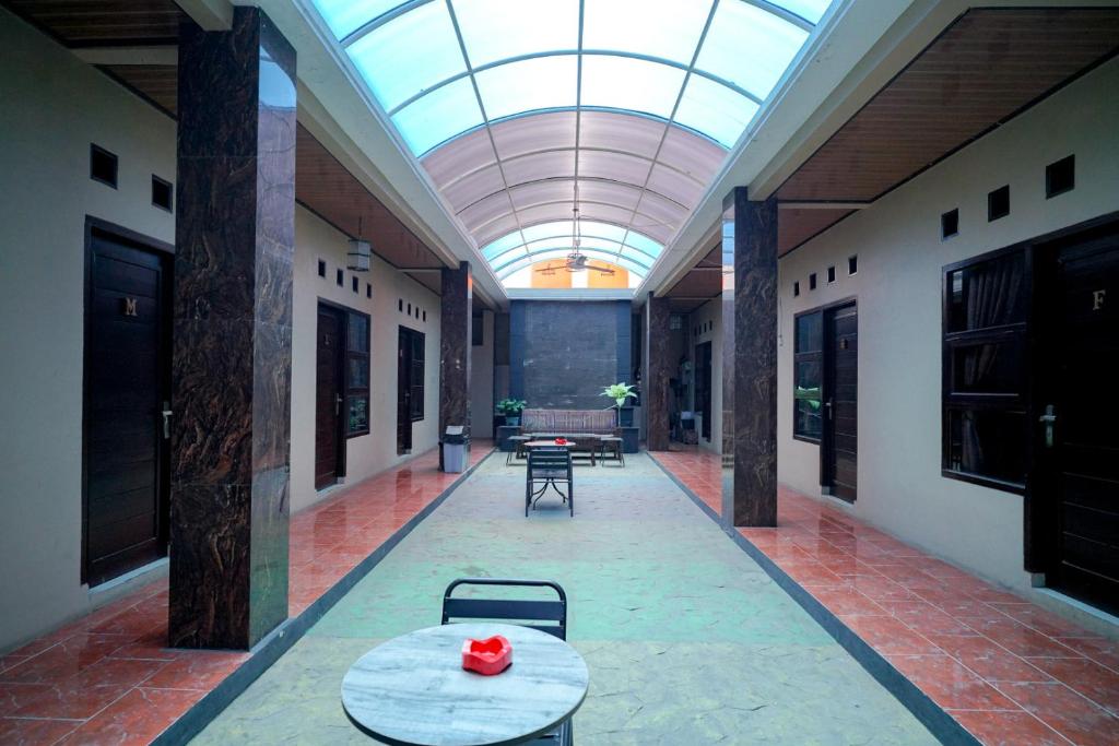 班达楠榜RedDoorz Syariah near Unila的走廊设有桌子和玻璃天花板