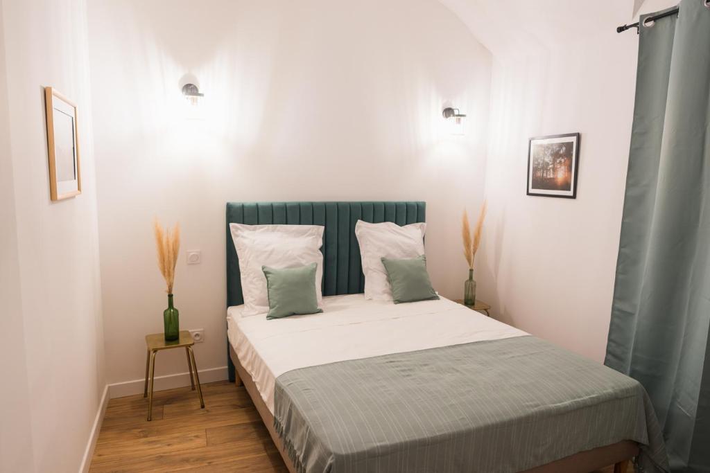 巴斯蒂亚Appartement cosy proche de la citadelle的卧室配有一张带白色床单和枕头的大床。