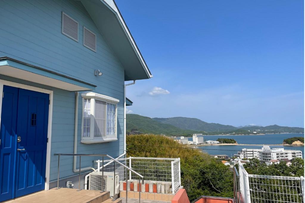 FuchisakiLa Classe Angel Road 2 - Vacation STAY 71497v的蓝色的房子,设有蓝色的门,享有水景