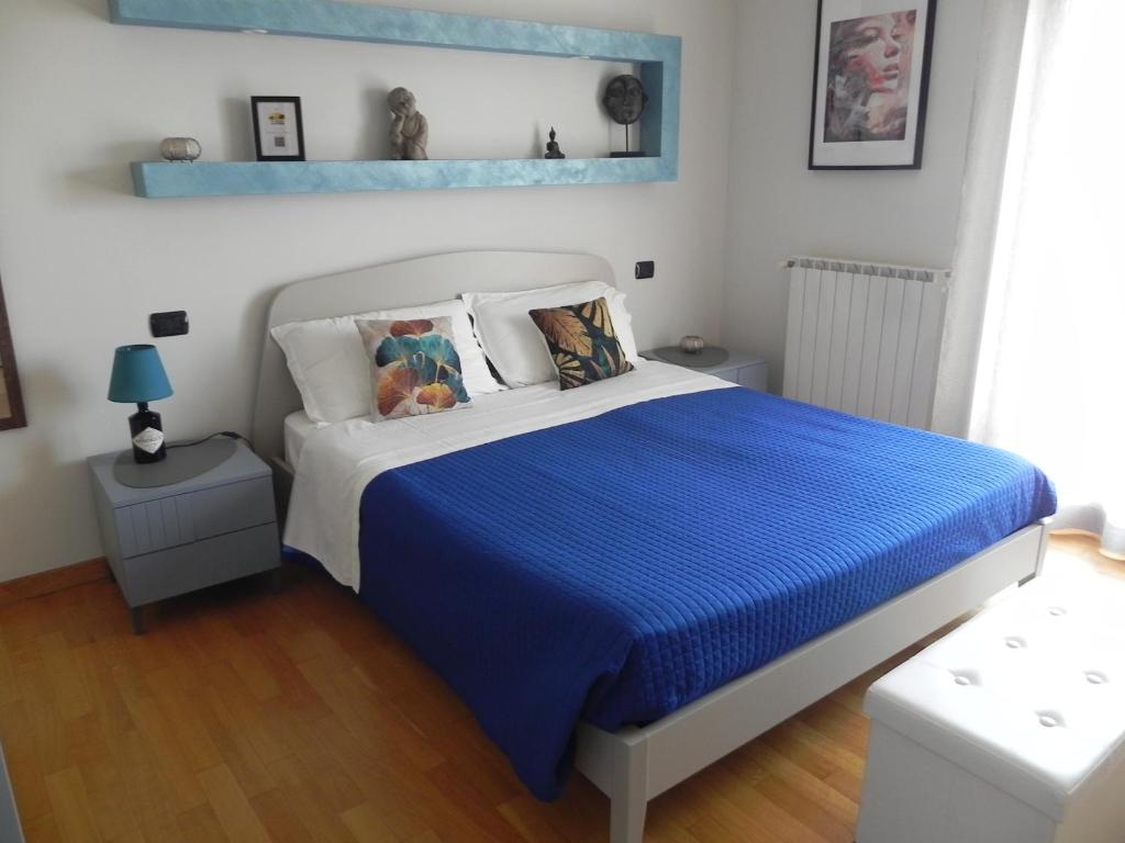 佩斯卡拉Hakuna Matata B&B的一间卧室配有一张带蓝色棉被的床