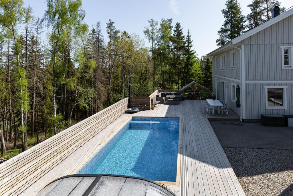 Spacious accommodation near Stockholm with heated pool的一个带游泳池和房子的后院