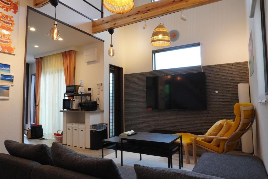 宫古岛きくのこ3缶ヴィラ＆テラス　的客厅配有沙发和墙上的电视