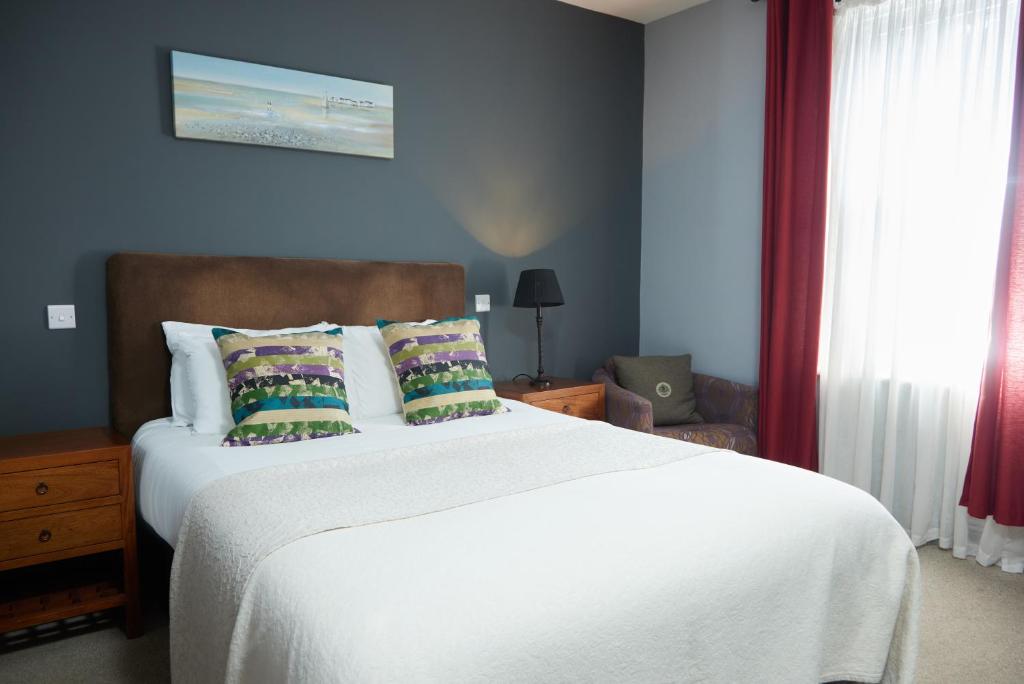 奇切斯特Trents by Greene King Inns的卧室配有一张带白色床单和枕头的大床。