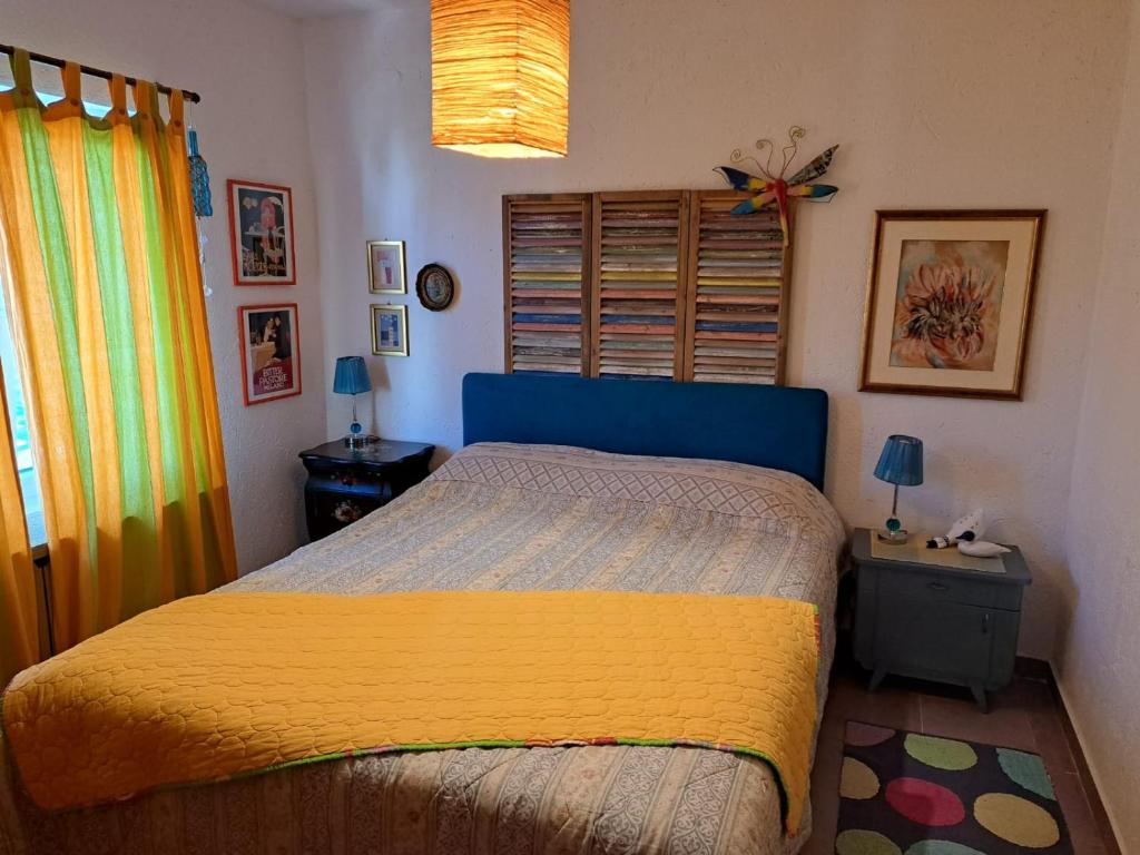克拉西奇Apartman Mafini的一间卧室配有一张黄色和蓝色毯子的床