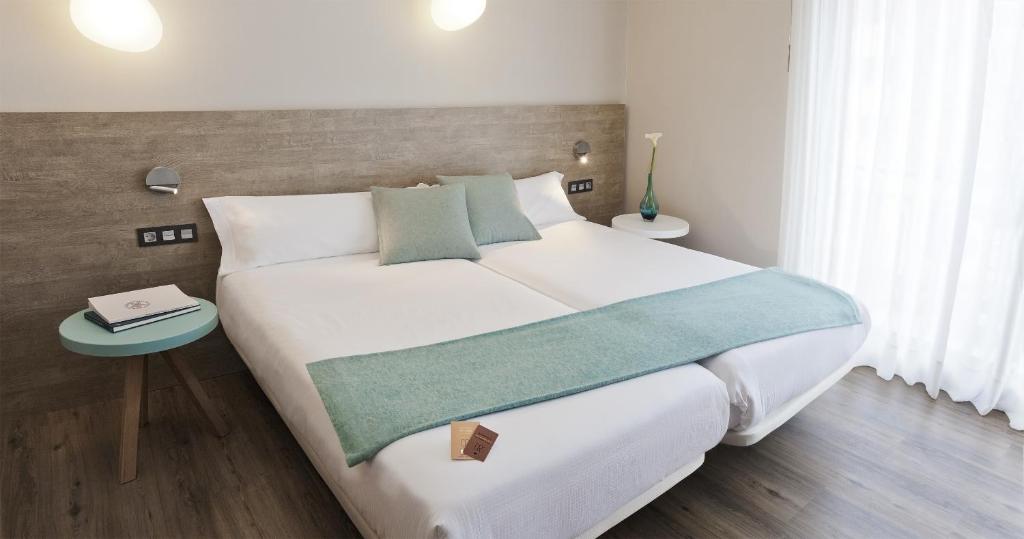 艾因萨Hotel Dos Rios Central的卧室配有一张白色的大床和一张桌子