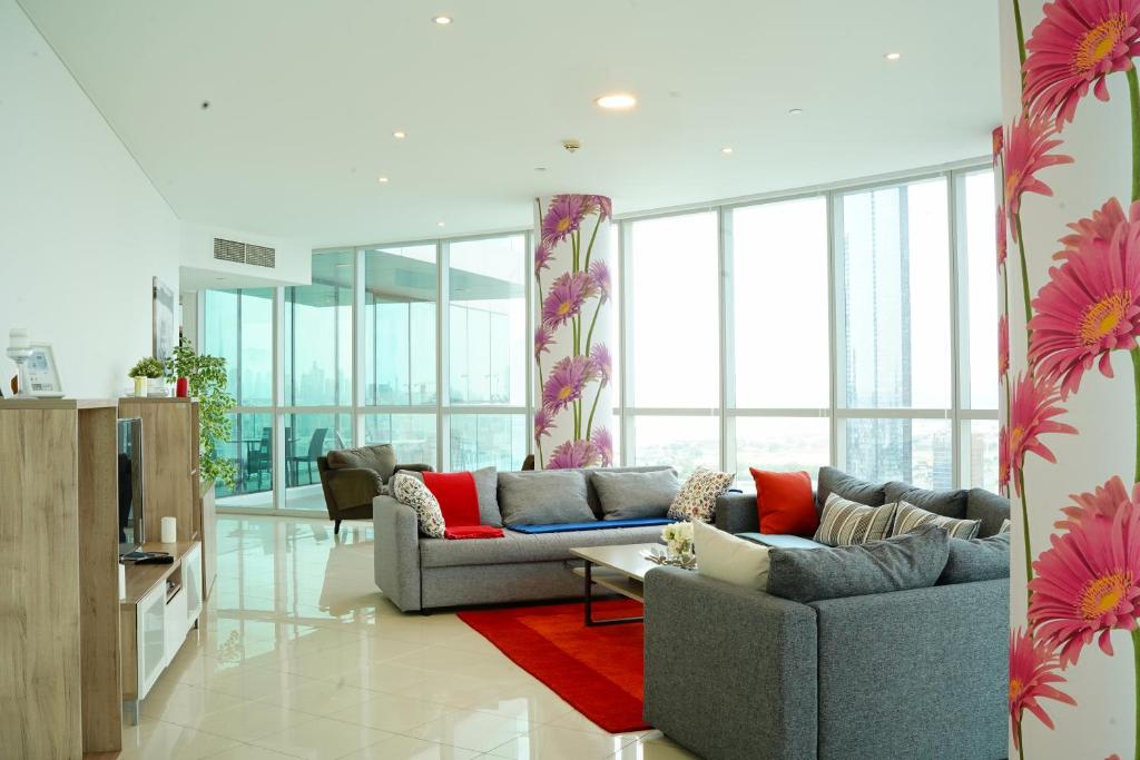 迪拜Luxurious Penthouses的客厅配有灰色的沙发和红色地毯。