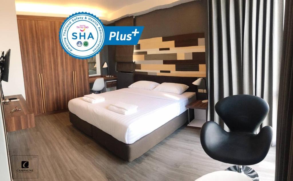 巴吞他尼Campagne Hotel and Residence - SHA Plus的酒店客房,配有一张床和一张黑椅