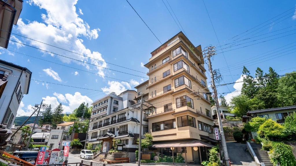 上田市中松屋传统日式旅馆的城市街道上一座高耸的公寓楼