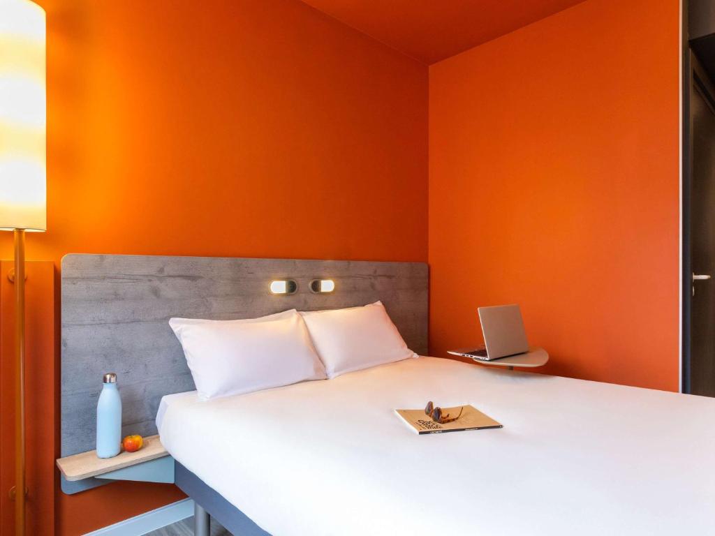 斯特拉斯堡ibis budget Strasbourg Centre Republique的一间卧室配有一张橙色墙壁的床