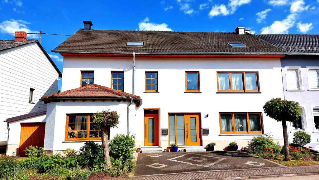 Ferienhaus Fisch的街上有橙色门的白色房子