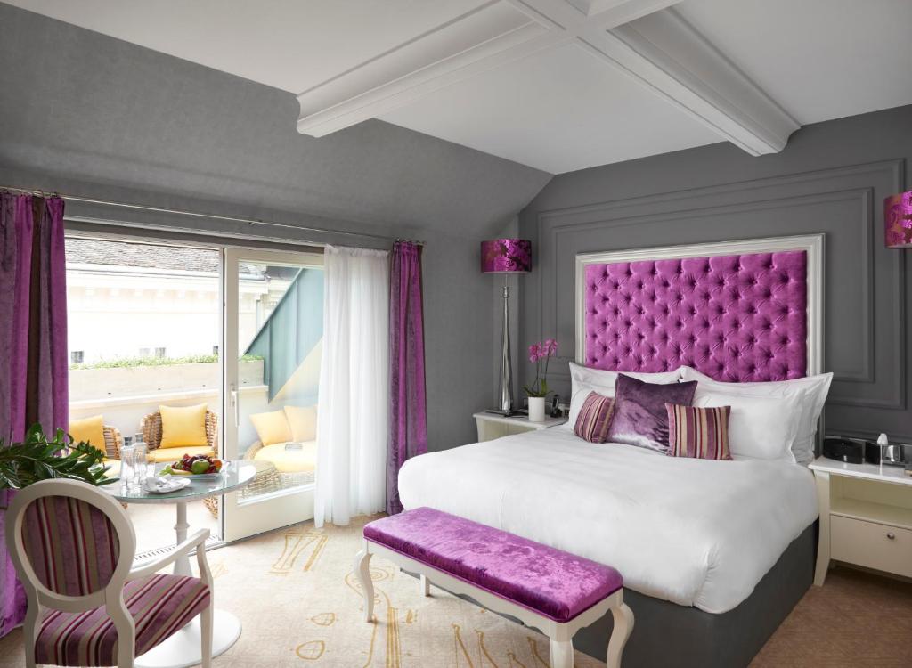 布达佩斯布达佩斯图书馆酒店集团咏叹调酒店的一间卧室配有一张大床和紫色床头板