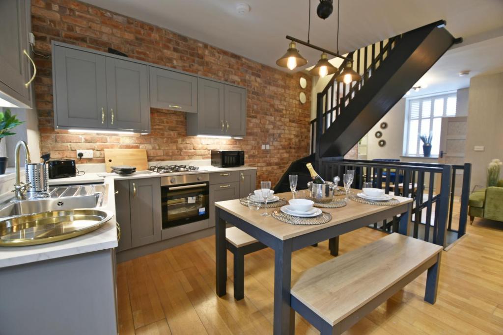 克利夫罗Quirky cottage set in Clitheroe的厨房以及带桌椅的用餐室。