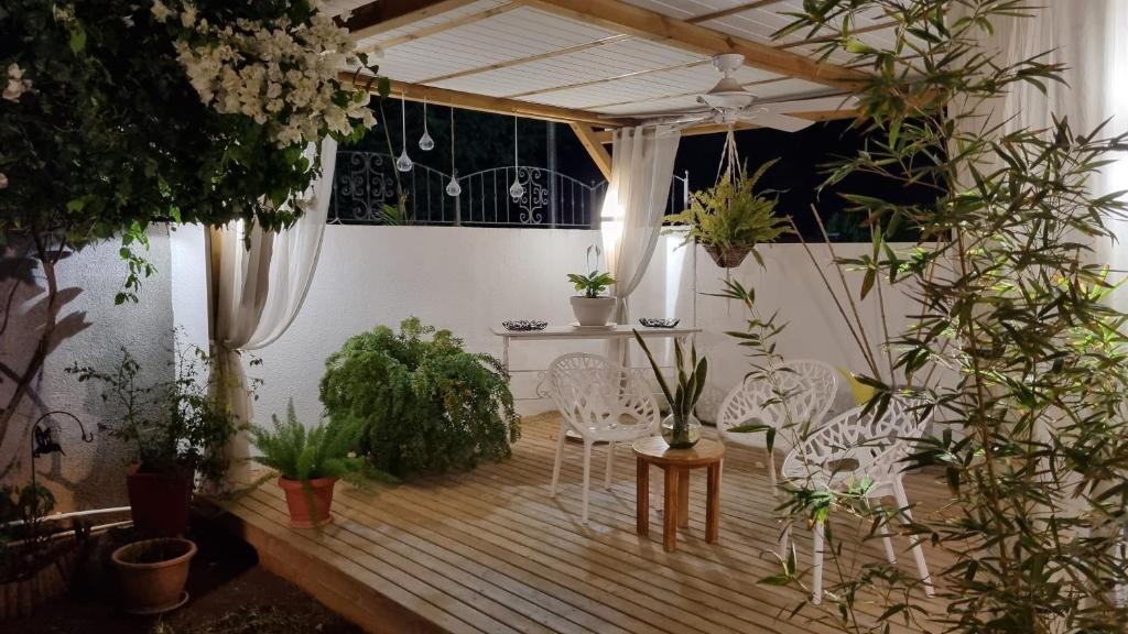PalmyreYour perfect getaway ...的庭院配有白色椅子和盆栽植物