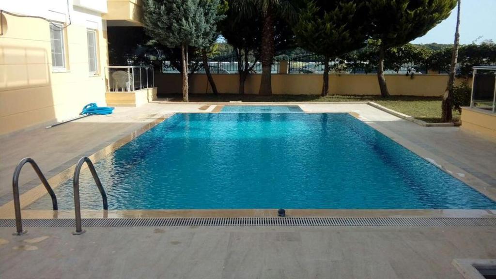 贝莱克SunSet Apartments 4,5,6的一座大型蓝色游泳池,位于房子旁边