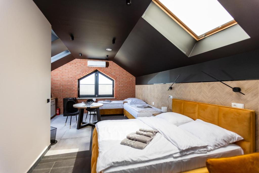 Hostel Dzika Kaczka的一间卧室设有一张大床和砖墙