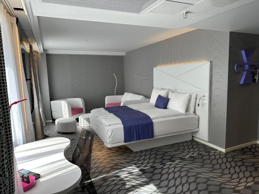 卑尔根Magic Hotel & Apartments Kløverhuset的一间卧室配有一张床和两把椅子