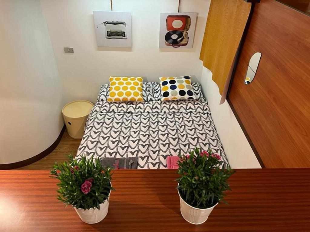 伊夫雷亚La Serra Olivetti的一张小床,位于一个有两盆植物的房间