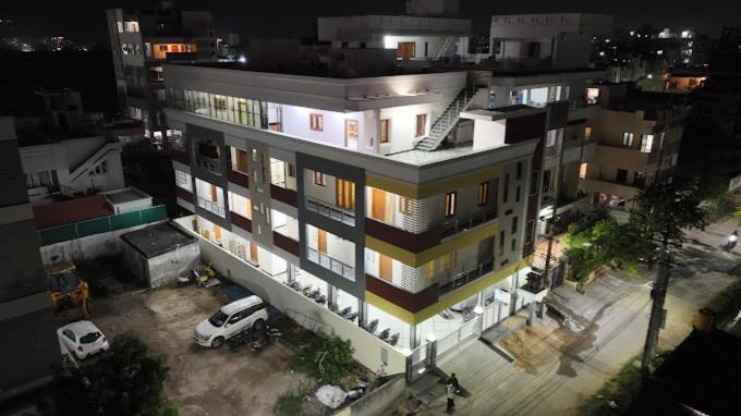 蒂鲁帕蒂Padma Homes Stay- Luxury Service Apartment 1BHK & 2BHK & 3BHK的前面有停车位的建筑