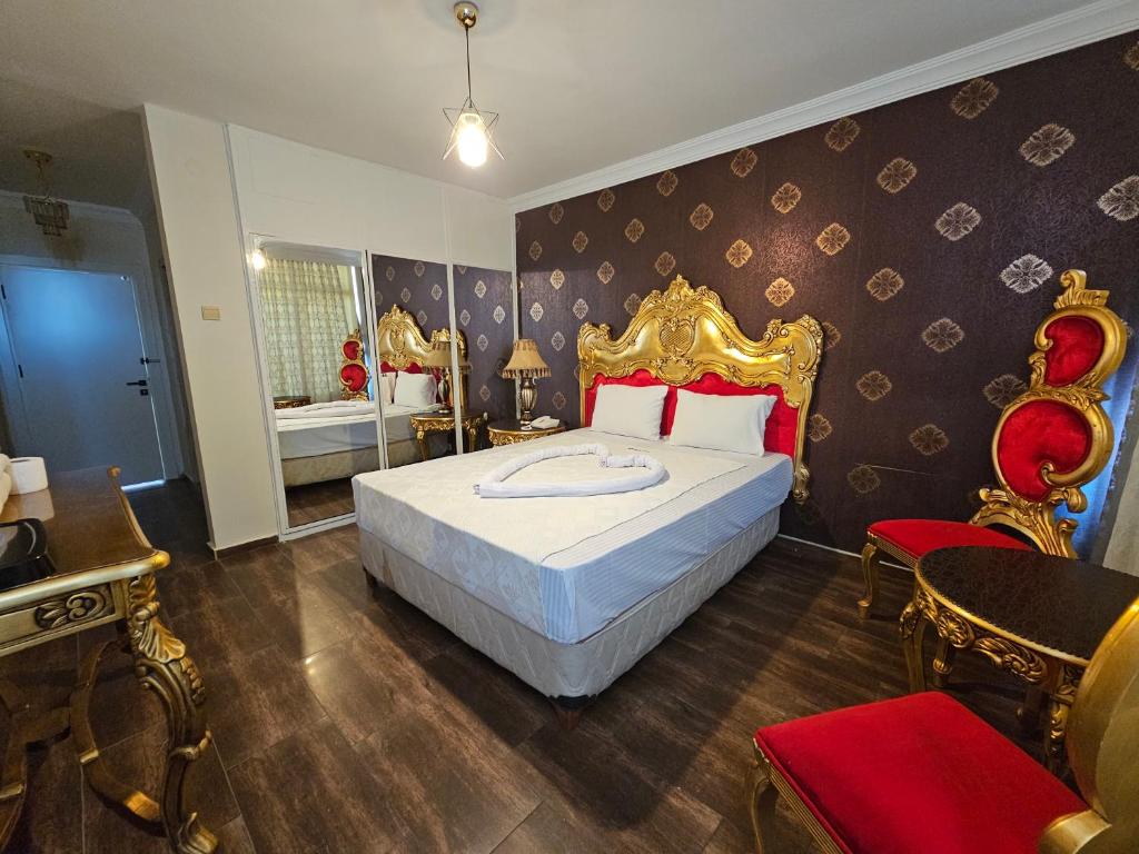 阿达纳Altın Koza Hotel的一间卧室配有一张大床和金色床头板