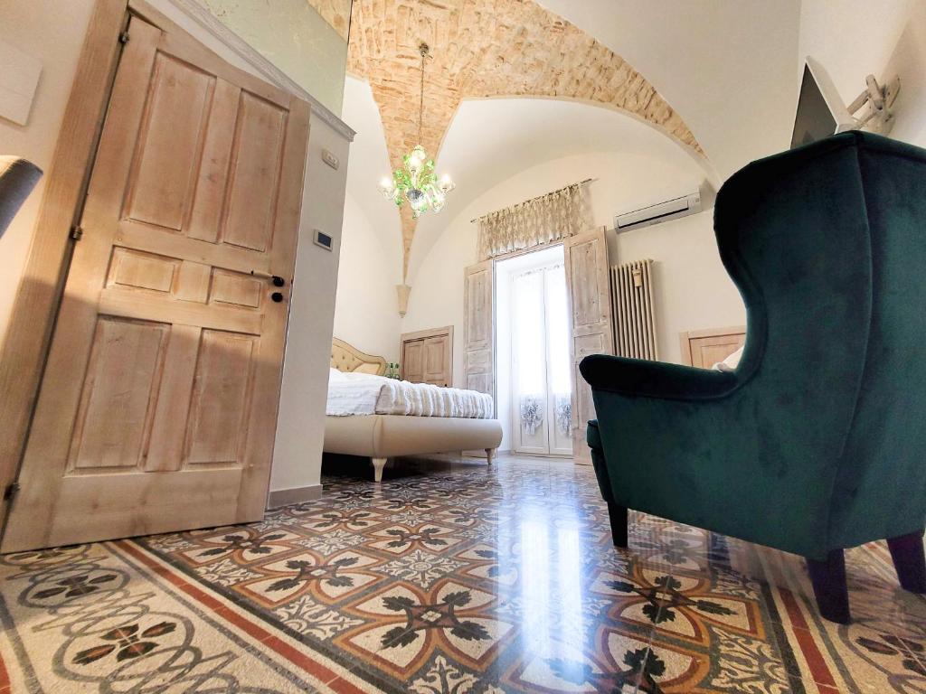 马丁纳弗兰卡ROSSINI GUEST HOUSE的一间带绿色椅子的客厅和一间卧室