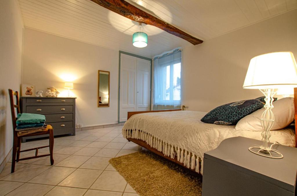 Mailly-le-CampLe gite de saint martin的一间卧室配有一张床和一张带台灯的桌子