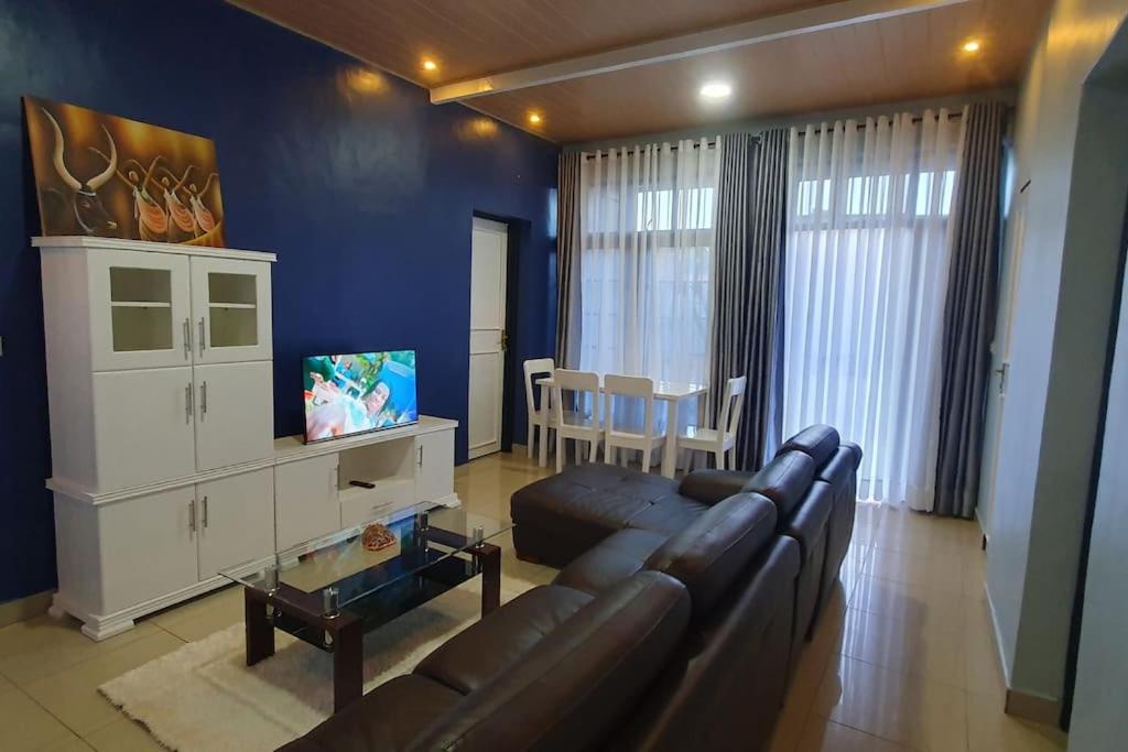 基加利Cozy Nest Oasis - Serviced Apartment的带沙发的客厅和用餐室