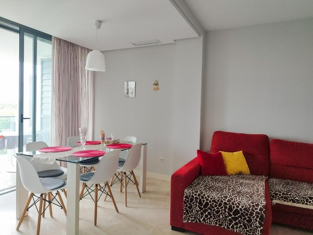 埃尔韦尔赫尔Apartamento bonito - playas las Deveses的客厅配有桌子和红色沙发