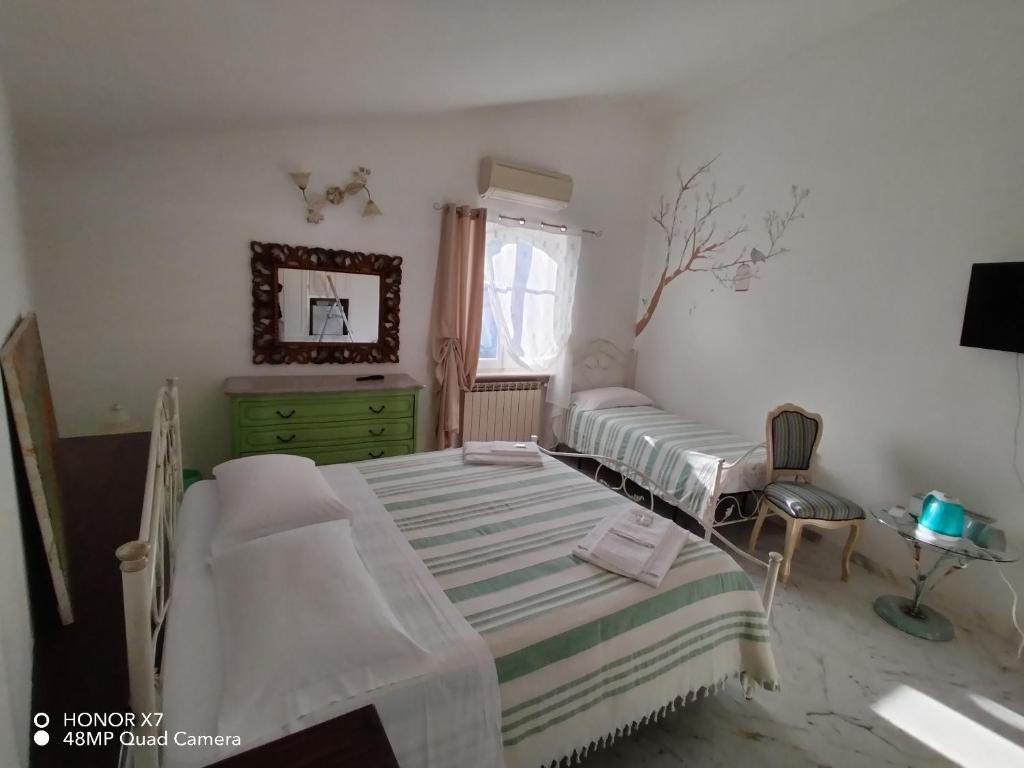 阿梅利亚IL CASALE DEL MAGRA的一间卧室设有两张床、一个梳妆台和窗户。