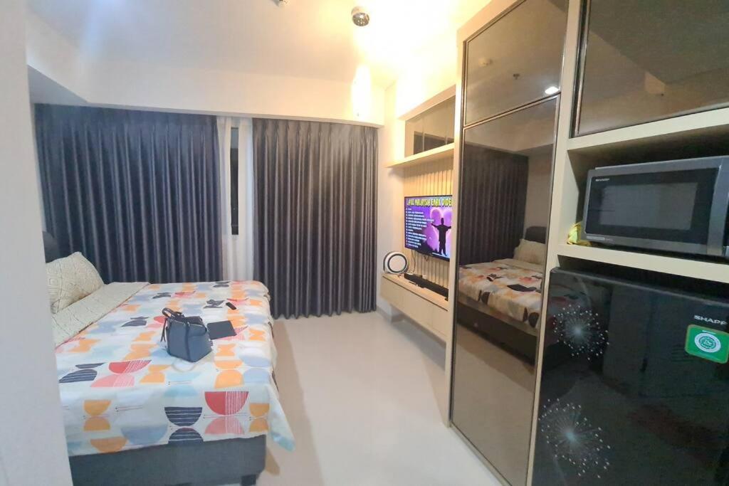 秾莎The Nove Apartment Junior Penthouse - Studio Type的酒店客房设有一张床和一台电视。