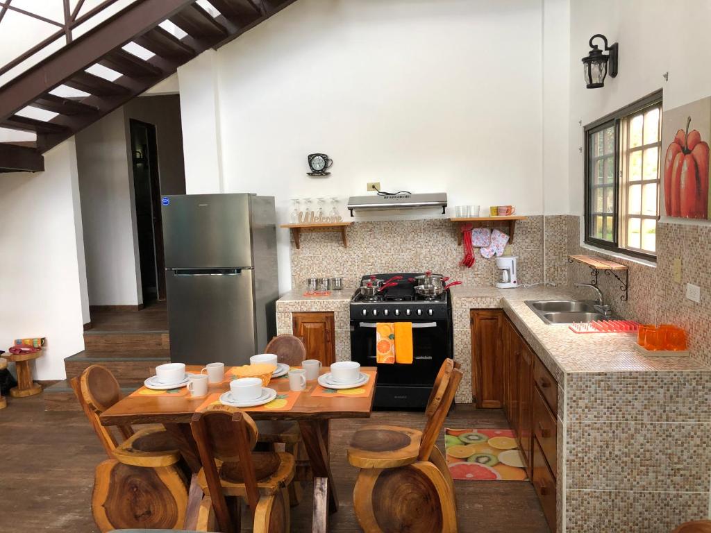 Alto BoqueteTu Cabaña en Boquete的厨房配有木桌和冰箱。