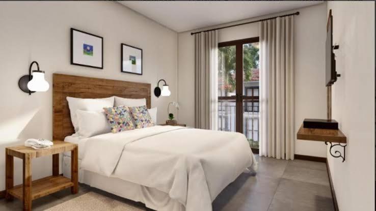 皮雷诺波利斯Suites Quinta Santa Barbara的白色的卧室设有一张大床和一个窗户