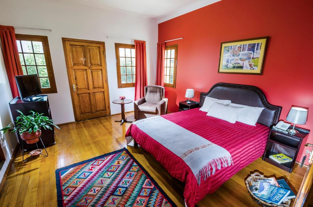阿雷基帕Hotel Boutique Selva Alegre的红色卧室配有床和椅子