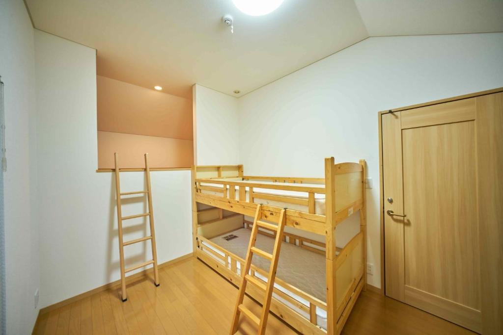 札幌Guest House Kingyo - Vacation STAY 14498的客房设有两张双层床和衣柜。