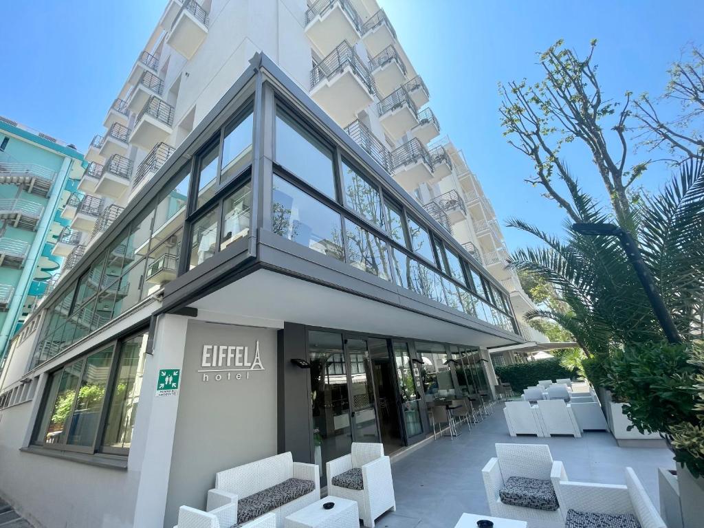 里米尼Hotel Eiffel的建筑前的白色椅子建筑