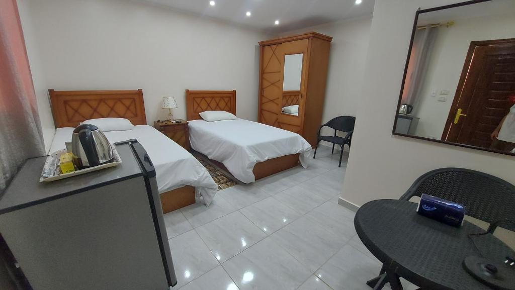 开罗Ramses Guest House的酒店客房设有两张床和一张桌子。