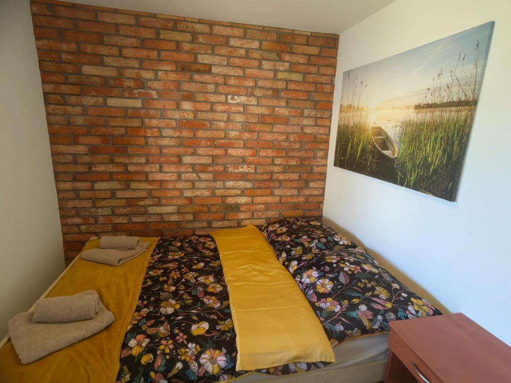 ŻarnowskaSiedlisko PoMaLeńku的卧室配有床,靠砖墙