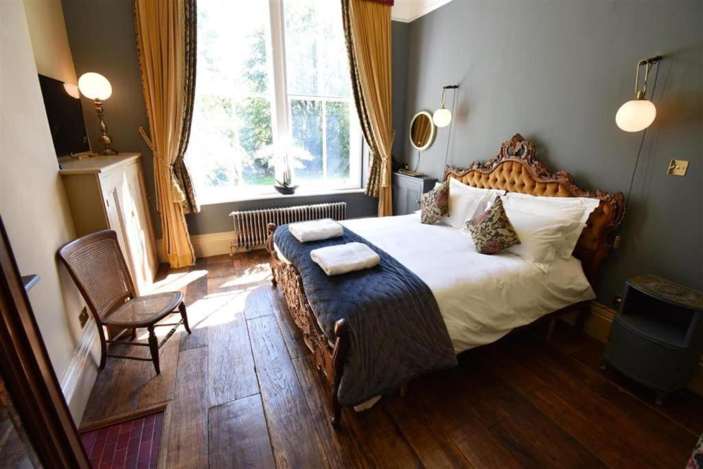 巴克斯顿The Huntress Suite的卧室配有床、椅子和窗户。