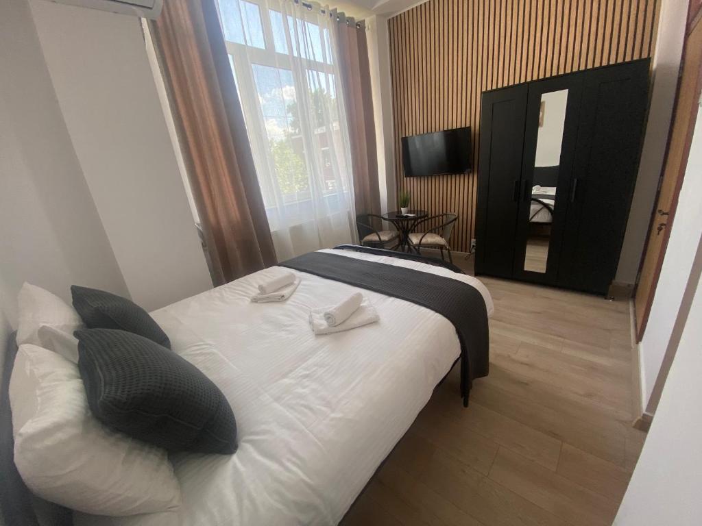 MogoşoaiaGarsoniera 27mp - Camera - Baie - Bucatarie - Balcon的卧室配有白色的床和大窗户