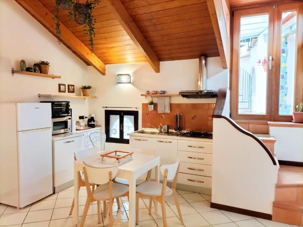 维耶特里NEL CUORE DI VIETRI CASA VACANZE AMALFI COAST的厨房配有白色橱柜和桌椅