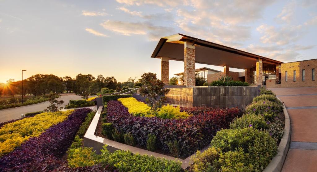 勒弗戴尔Rydges Resort Hunter Valley的一座建筑前面有鲜花花园