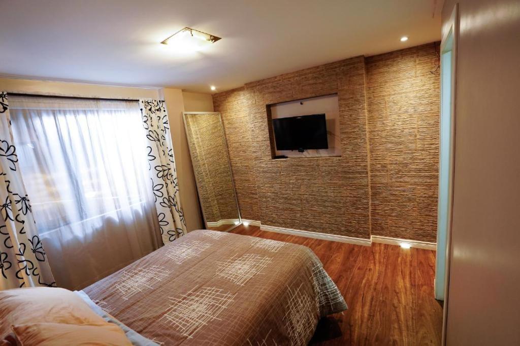 昆卡Apartamento con jacuzzi y Parqueadero的一间卧室配有一张床,墙上配有电视