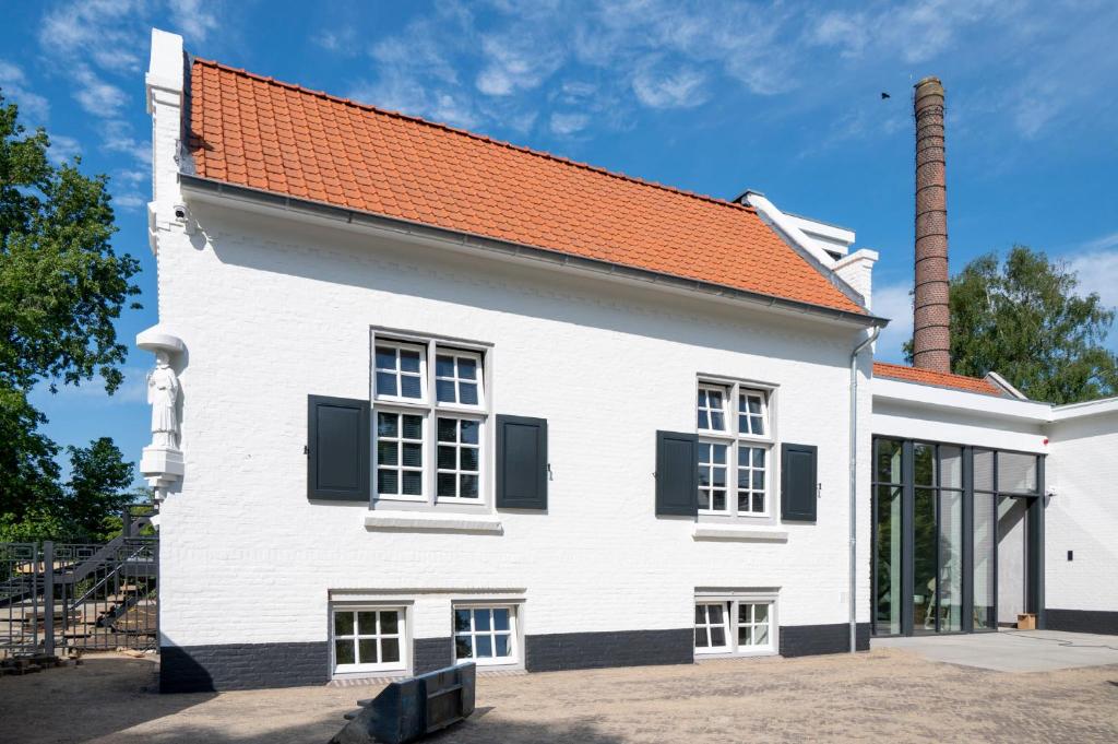 Sint-OedenrodeLindenhuys Logies的白色的建筑,有红色的屋顶