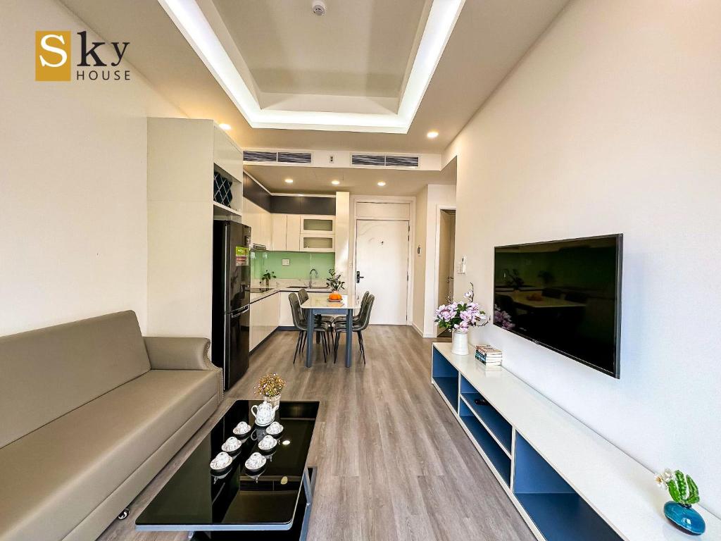 谭奎Sky House Apartment的客厅配有沙发和墙上的电视