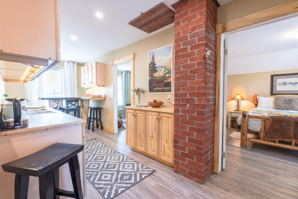 卡尔加里Craftsman's Loft - Heritage charm - AC - 5 min DT的厨房以及带砖墙的起居室。