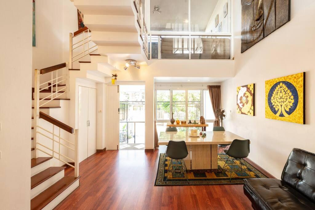 曼谷420 House- up to 10 guests in central Bangkok.的客厅设有餐桌和楼梯。
