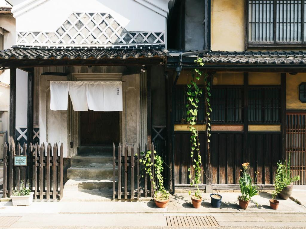 出云市RITA Izumo Hirata的一座古老的建筑,前面有盆栽植物