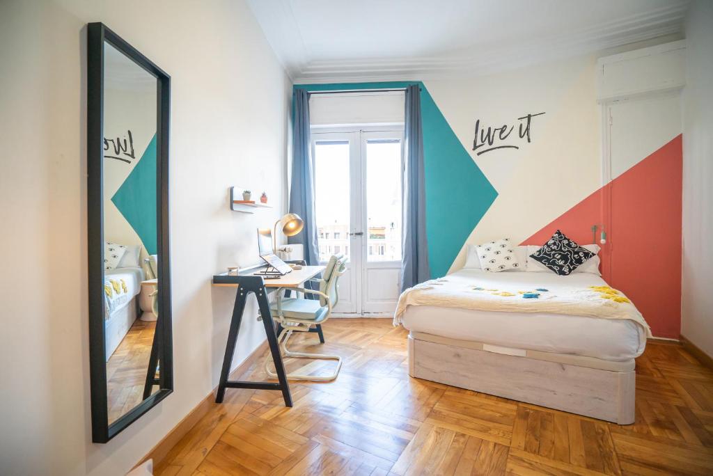 马德里Live It Madrid Chamberi的一间卧室配有一张床、一张书桌和一面镜子