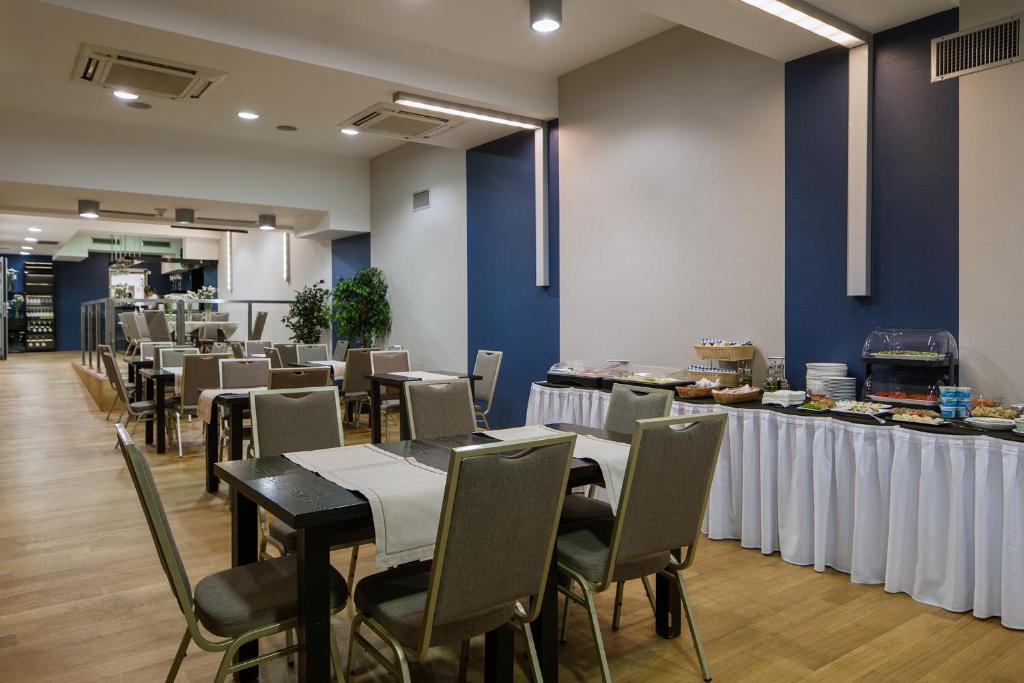 克拉科夫中心商务酒店的一间配备有桌椅的用餐室和蓝色的墙壁